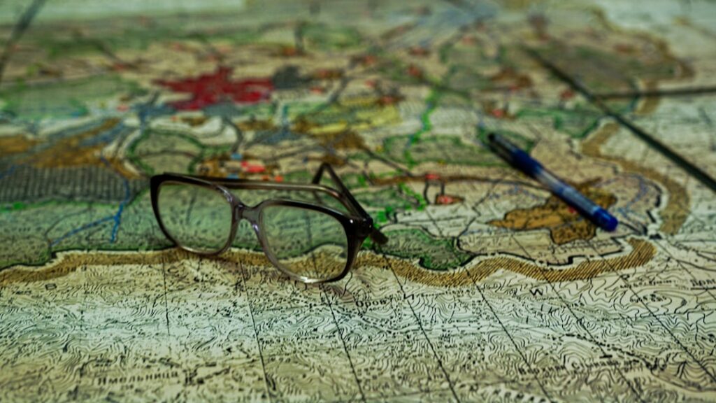 Shiny brass compass and a set of modern house keys resting on a map, symbolizing guidance and direction in the real estate...