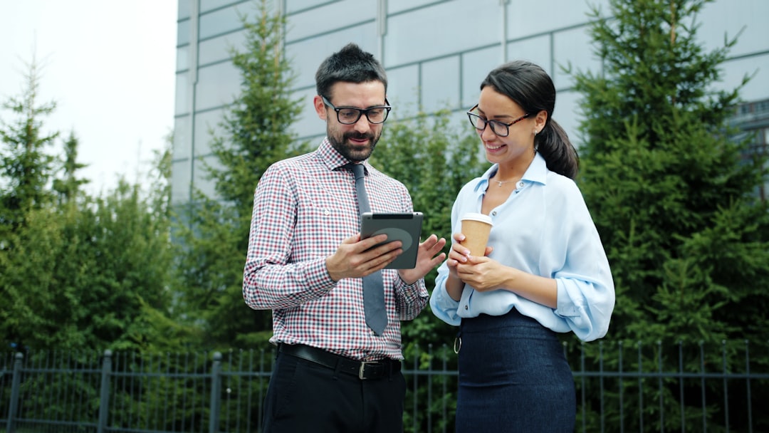Two people sit at a bright, minimalist desk, professionally negotiating and reviewing real estate contracts.