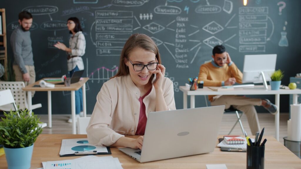 Man and a woman in professional attire have a serious consultation across a modern desk in a bright, well-lit office.