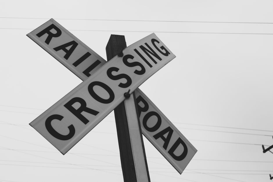 A man stands at a crossroads with multiple street signs pointing in different, confusing directions, representing the challenge of navigating the real estate market.