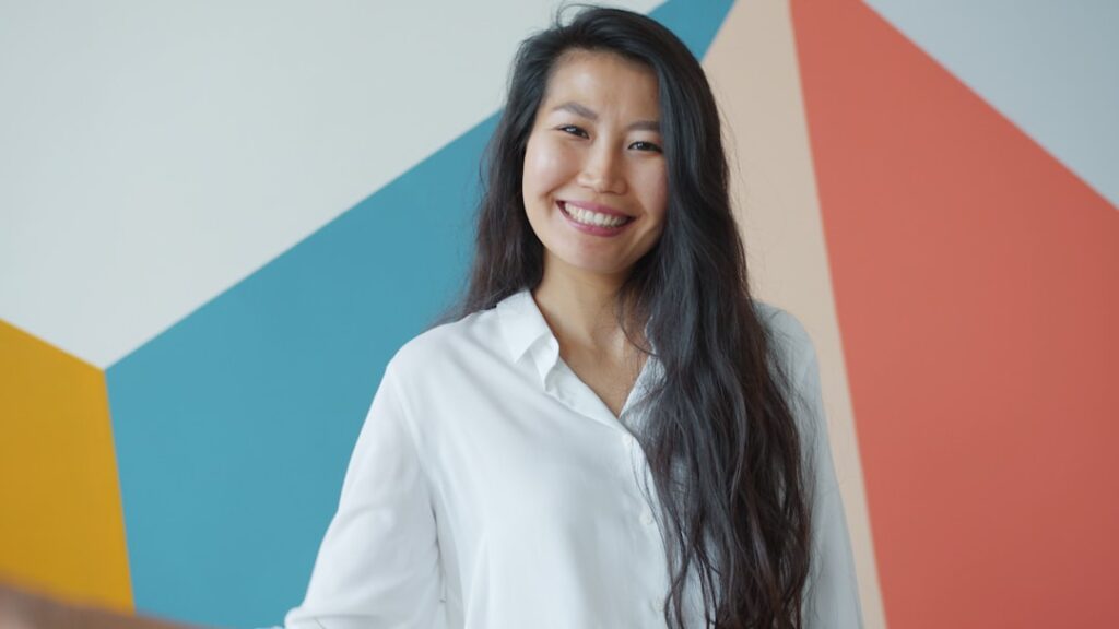 Professional and trustworthy real estate agent smiling confidently in a modern, brightly lit office setting.