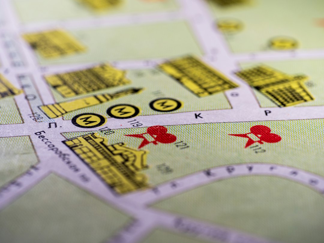 A close-up of a hand carefully placing a pin on a specific neighborhood of a city map, representing the importance of hyper-local SEO targeting for realtors.